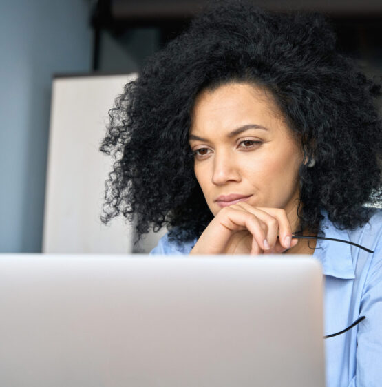 Image shows a closeup portrait of serious African American woman taking online training from Baker EEO Services.
